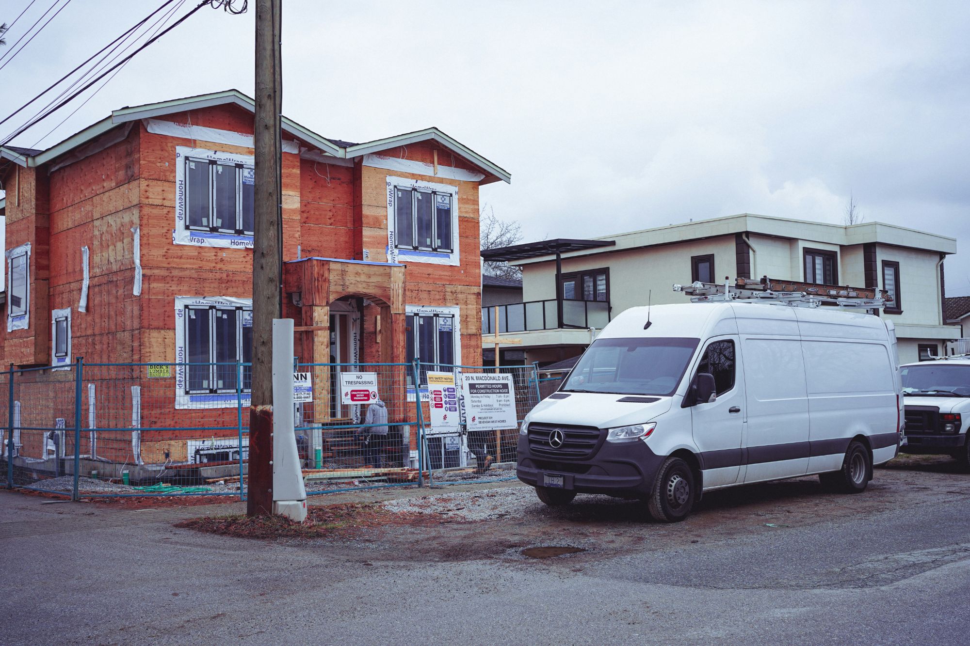 A contractor's white van parked by a building site